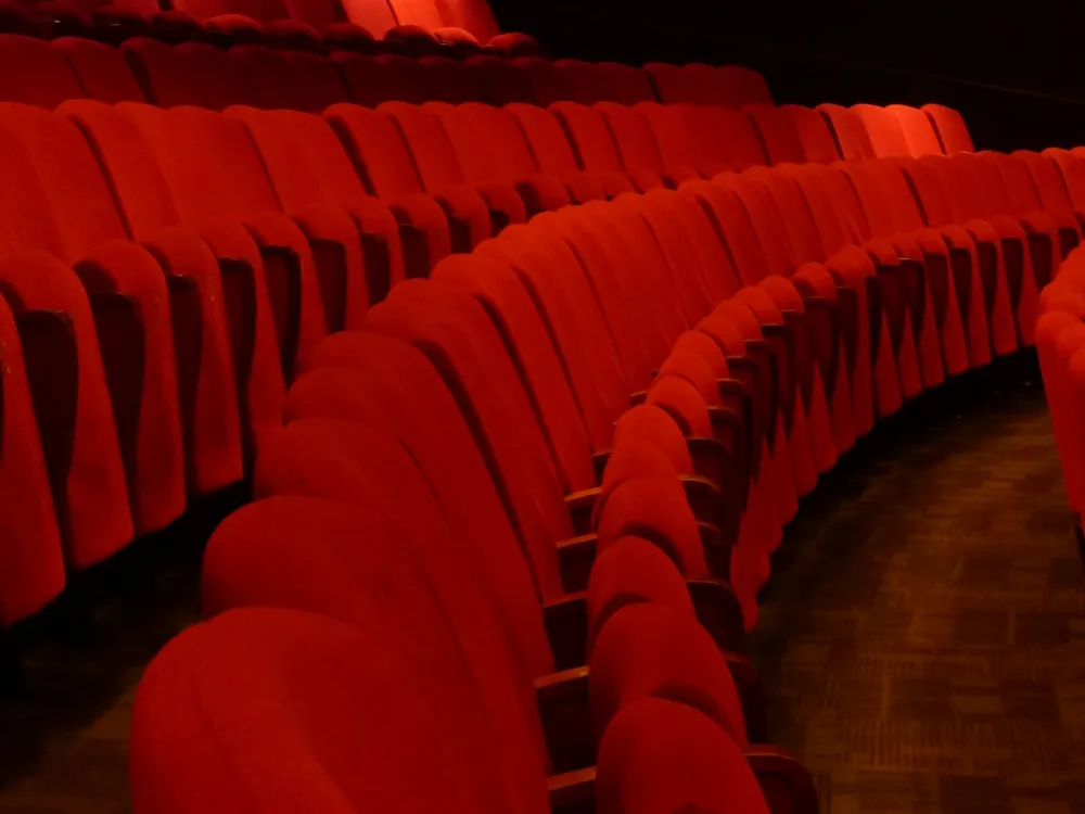 Rows of curved red theatre seating rising toward the back of an auditorium